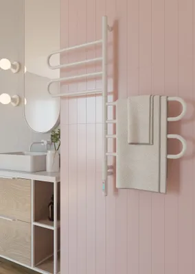 A modern bathroom with a white towel rack mounted on a pink tiled wall.