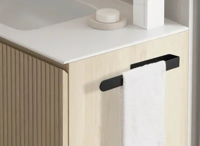 A close-up view of a bathroom vanity with a towel rack and a white towel.