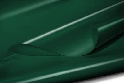 A close-up, abstract shot of a dark green, glossy material, likely PVC tarpaulin, with a section folded over, creating curves and highlights.