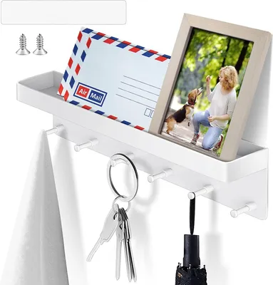 A white key rack with a shelf, holding an air mail envelope, a framed photo of a woman and a dog, a towel, keys, and a folded umbrella.