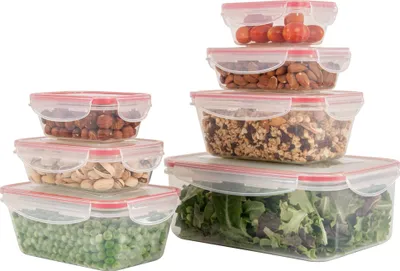 A set of seven clear plastic food storage containers with red lids, filled with various food items.