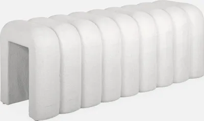 A white upholstered bench with a ribbed design.