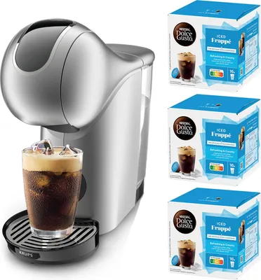 A silver Krups Dolce Gusto coffee machine with a glass of iced coffee, and three boxes of Nescafé Dolce Gusto Iced Frappé capsules.