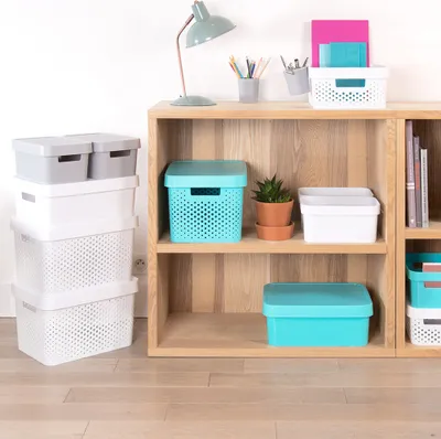 Storage boxes are neatly arranged on shelves and next to a bookshelf.