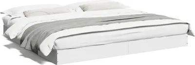 A white bed frame with white and gray bedding, shown from a side-angle.