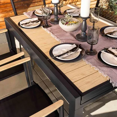 A dining table set for a meal outdoors.