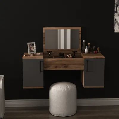 A modern vanity table with a mirror and two drawers, set against a black wall. A white pouf is placed in front of the table.