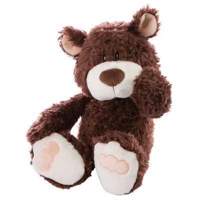 A brown teddy bear is sitting with its legs extended and one paw raised to its face.