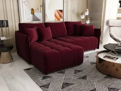 A modern living room with a dark red sectional sofa, coffee table, and artwork.