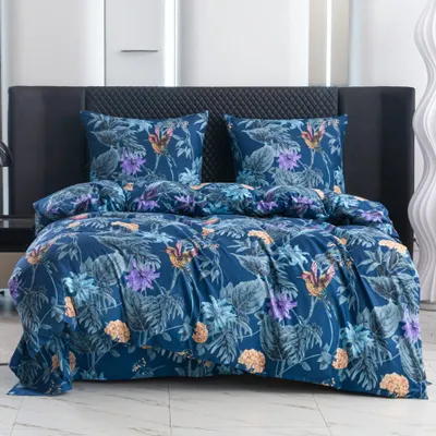 A neatly made bed with a floral patterned duvet and pillows.