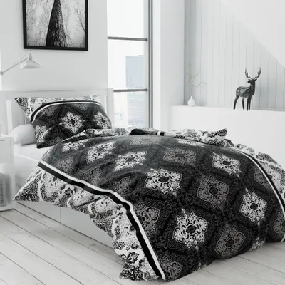 A bedroom scene with a bed made with black and white patterned bedding.