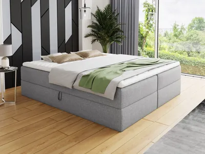 A bedroom scene with a bed, nightstand, and window view.