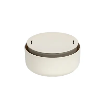 A close-up studio shot of a round, cream-colored container with a gray lid.