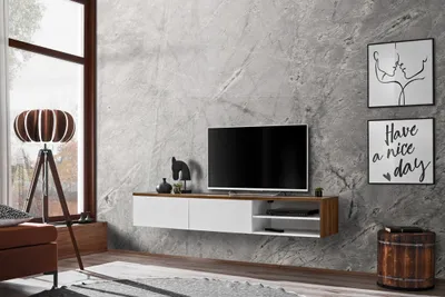 A modern living room with a TV stand, TV, and decorative items.