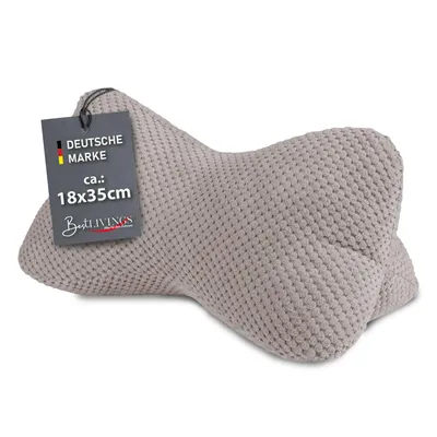 A taupe-colored bone-shaped pillow with a tag attached.