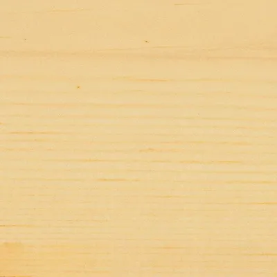 A close-up of a light-colored wooden surface with visible grain.