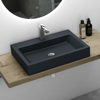 A modern bathroom sink with a faucet and two soap dispensers on a wooden shelf.
