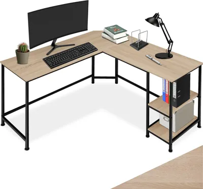 An L-shaped desk with a computer, keyboard, lamp, books, and storage shelves.