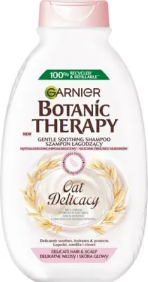 A white bottle of Garnier Botanic Therapy Oat Delicacy shampoo with pink accents and a graphic of wheat stalks.