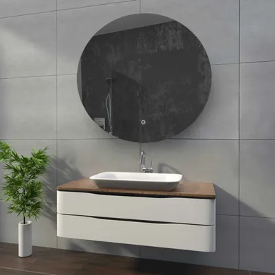 A modern bathroom vanity with a sink and a round mirror above it.