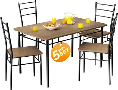 A dining table with four chairs, set up in a studio setting with some food and drinks on the table.