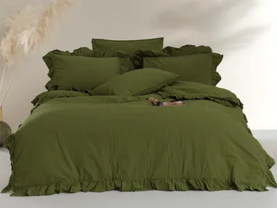 A neatly made bed with olive green bedding and decorative pillows.