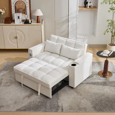 A white sofa bed is shown in a living room setting, with a side table and a cabinet in the background.