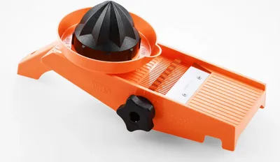 An orange and black vegetable slicer with a citrus juicer attachment is shown on a white background.