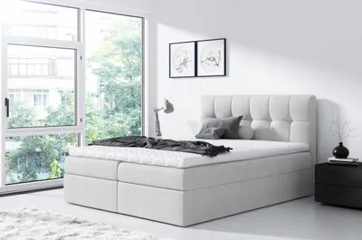 A bedroom scene with a bed and a large window.