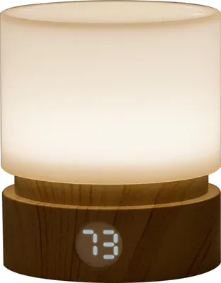 A close-up studio shot of a small, cylindrical LED night light with a wood-grain base.