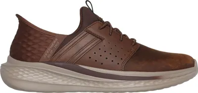 A side view of a brown SKECHERS SLIP-INS SLADE - ZACHARY shoe against a white background.