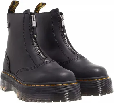 A pair of black Dr. Martens boots with zippers on a white background.