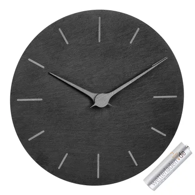 A round, black analog wall clock with silver hands and hour markers, shown on a white background. A single AA battery is placed to the right of the clock.