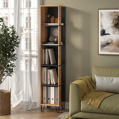 A tall, narrow bookshelf filled with books and decorative items, placed next to a window with sheer curtains and a green sofa with a yellow throw blanket.