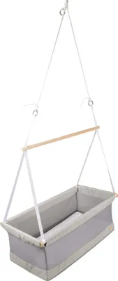 A hanging baby bassinet suspended by white cords and a wooden bar.