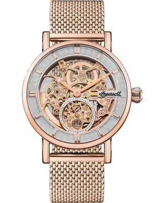 A close-up, front-facing studio shot of a skeletonized automatic wristwatch with a rose gold case and mesh band.
