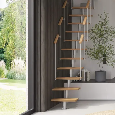 A modern spiral staircase with wooden steps and metal railings is shown in a well-lit room with a large window overlooking a garden.