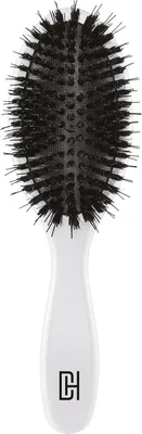 A white hairbrush with black bristles is shown against a white background.