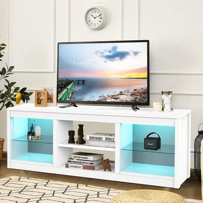A white TV stand with a television on top, decorated with various items and illuminated by blue LED lights.