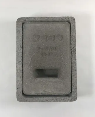 A close-up, top-down view of a gray concrete chimney flap with embossed text.