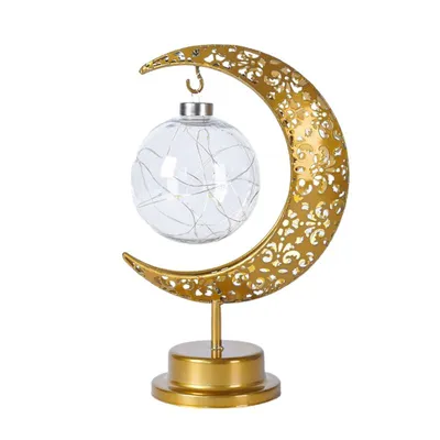A decorative lamp shaped like a crescent moon with a glass orb containing fairy lights.