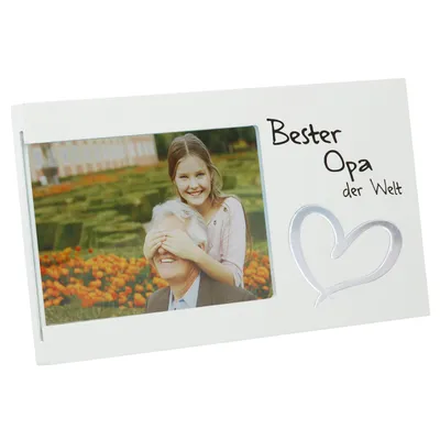 A photo frame with a picture of a girl covering a man's eyes, with text and a heart design.