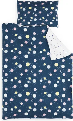 A flat lay of a children's duvet cover and pillowcase set with a space-themed print.