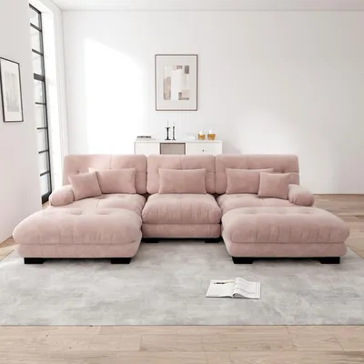 A large, U-shaped sectional sofa in a soft pink chenille fabric is arranged in a modern living room setting.