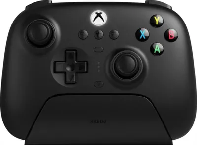 A black Xbox controller with a charging dock.