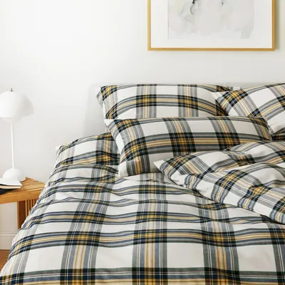 A close-up view of a bed with plaid bedding.