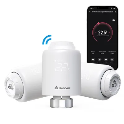 A set of three white smart thermostats for radiators, with a smartphone displaying the thermostat's app interface in the background.