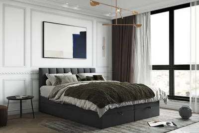 A bedroom with a bed, artwork, and curtains.