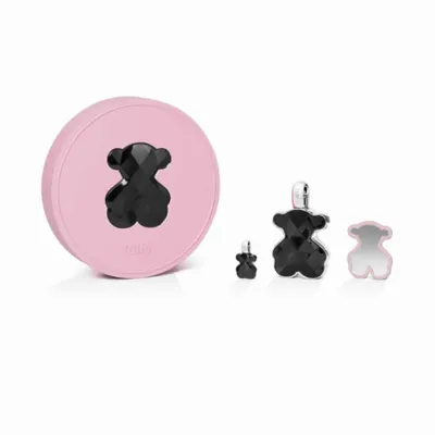 A pink circular box with a black bear-shaped gem on it, and three black bear-shaped gems of different sizes next to it, one with a silver loop.