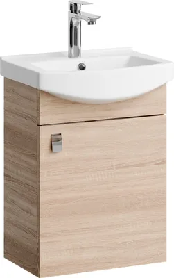 A white sink with a chrome faucet sits atop a light brown wooden cabinet with a silver handle.